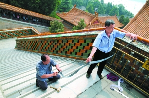 昨天，颐和园的工作人员在佛香阁给石台阶贴防滑条，防止游客滑倒。本报记者 吴镝摄